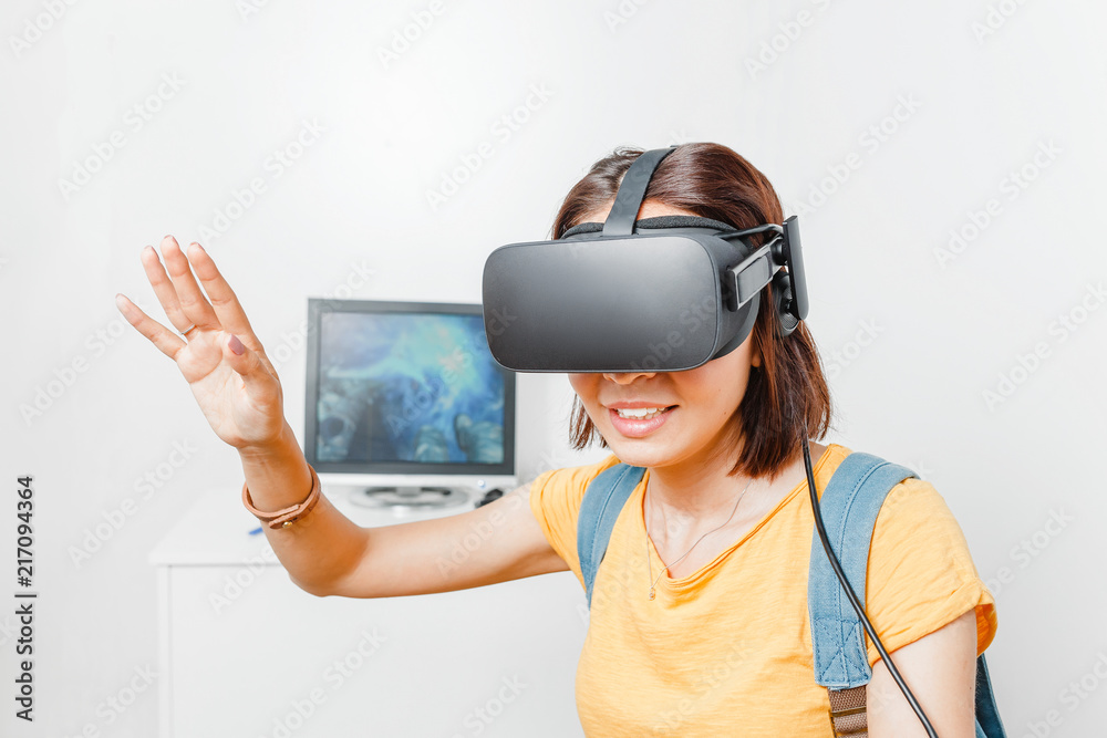 Woman playing video game with virtual reality VR headset against computer  monitor Stock Photo | Adobe Stock