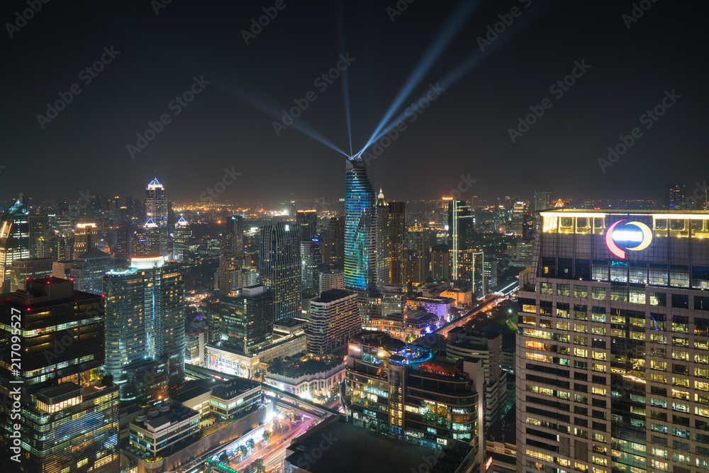 Naklejka premium Night view with skyscraper in business district in Bangkok Thailand. Light show at Magnolias Ratchaprasong in Bangkok, Thailand.
