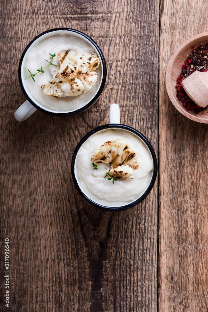 Healthy cauliflower cream soup in rural mugs, top view Healthy cauliflower cream soup in rural mugs, top view
