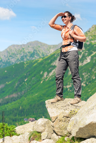 a tourist on the edge of the cliff enjoys the beautiful scenery of the mountains