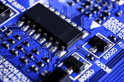 Macro shot of a Circuitboard with resistors microchips and electronic components. Computer hardware technology. Integrated communication processor in blue tones. Semiconductor. PCB. Closeup