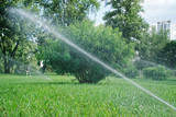 Sprinkler system watering grass in park, splash water