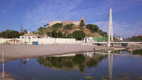 Pedestrian bridge and spanish medieval castle view with flag on top - still shot photo