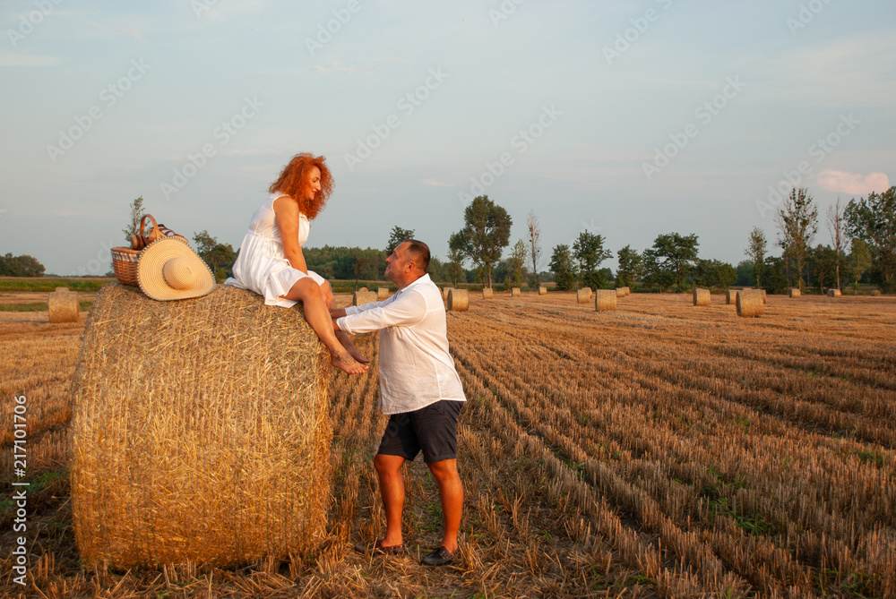 Romantic rendezvous on a freshly cut field near a haystack Romantic rendezvous on a freshly cut field near a haystack