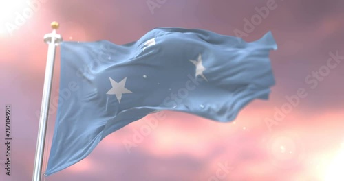 Flag of the Federated States of Micronesia waving at wind at sunset in slow, loop photo