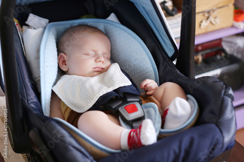 Cute little boy is sitting in carseat photo