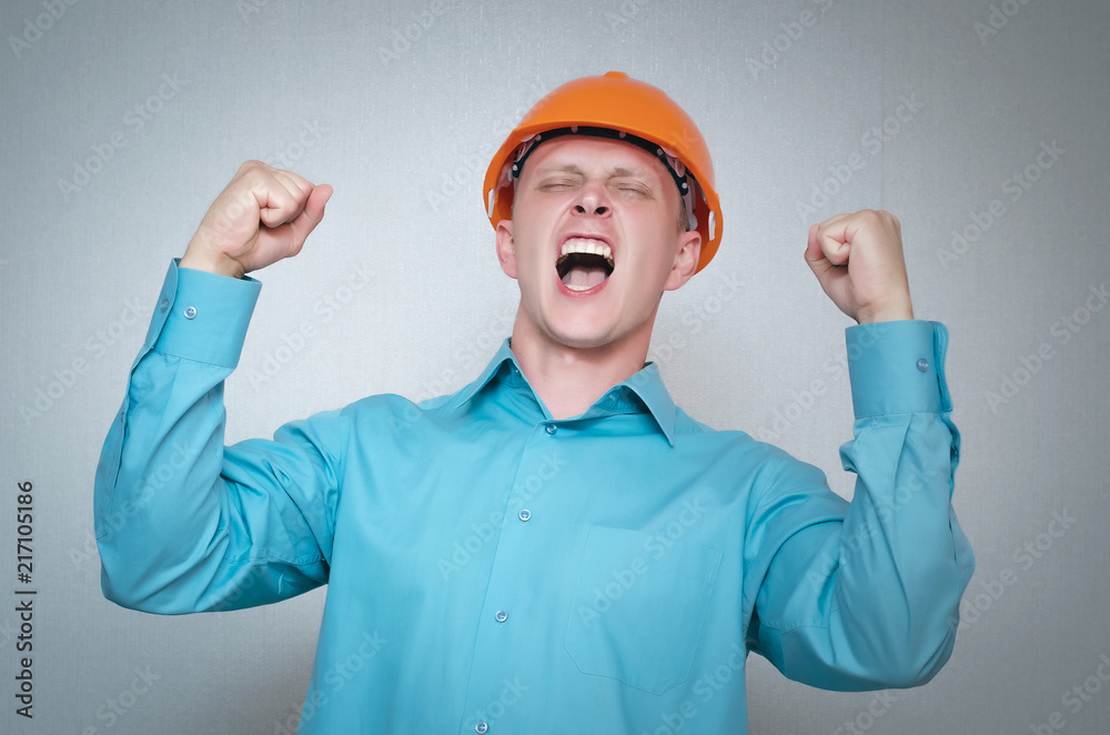 Successful builder worker man closes his eyes from happiness. Worker won a contract for construction and repair isolated on gray background. Successful builder worker man closes his eyes from happiness. Worker won a contract for construction and repair isolated on gray background.
