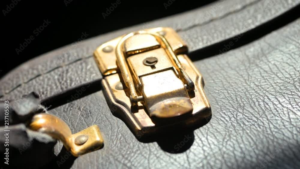 Closing the brass latch on an acoustic guitar case. Closing the brass latch on an acoustic guitar case.
