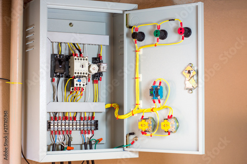 Electrical terminal box. Control panel with magnetic contactor and overload relay. Checking cartridge fuse on main distribution board.