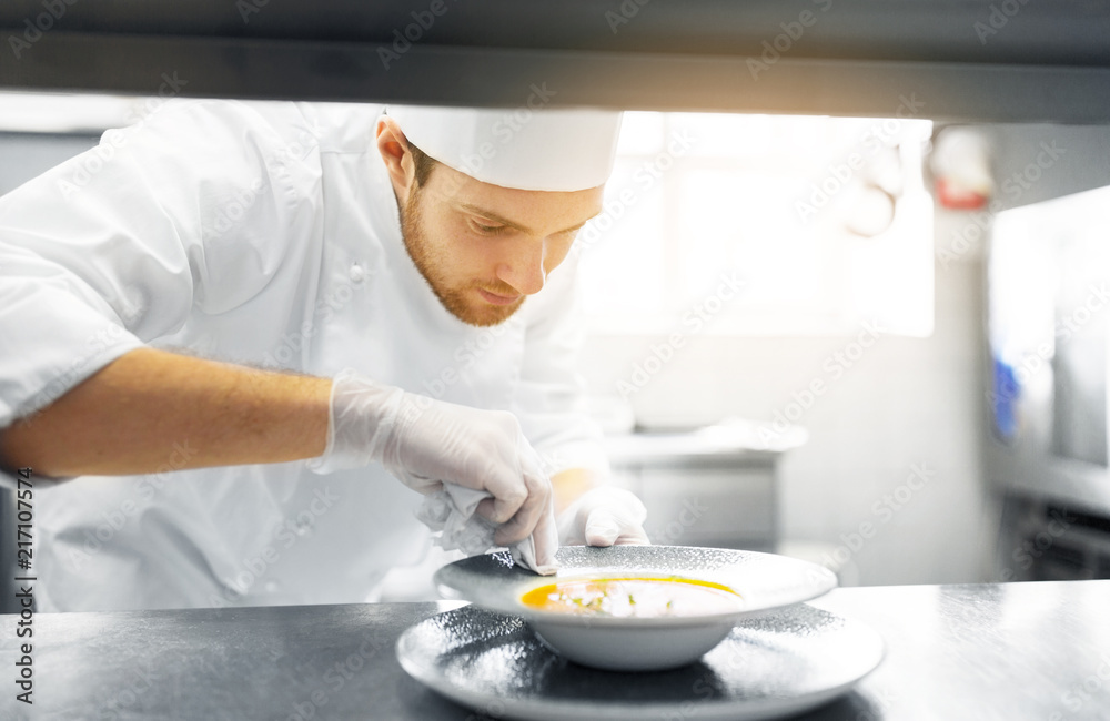 food cooking, profession and people concept - happy male chef cook serving plate of soup at restaurant kitchen food cooking, profession and people concept - happy male chef cook serving plate of soup at restaurant kitchen