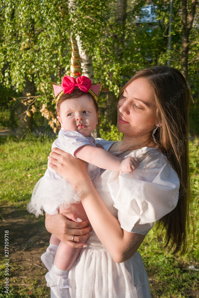 beautiful young mother with a little daughter in the forest at a photo session near the pond
