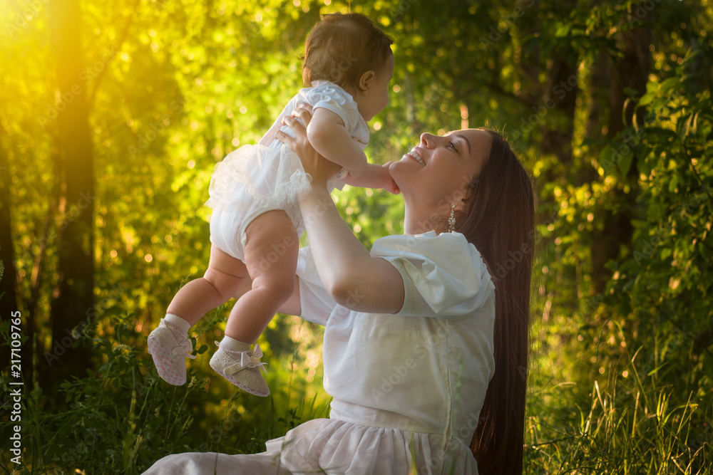 beautiful young mother with a little daughter in the forest at a photo session near the pond
