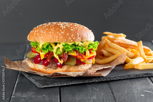 Hamburger with fries on a slate plate