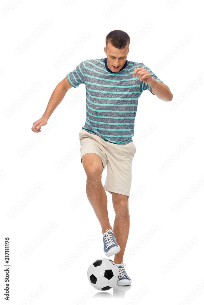 sport, leisure and people concept - young man freestyle juggling soccer ball over white background sport, leisure and people concept - young man freestyle juggling soccer ball over white background