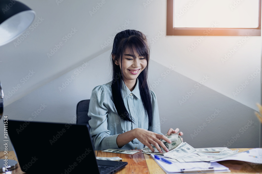 Successful business women are counting money and throwing a dollar at work happily. Successful business women are counting money and throwing a dollar at work happily.