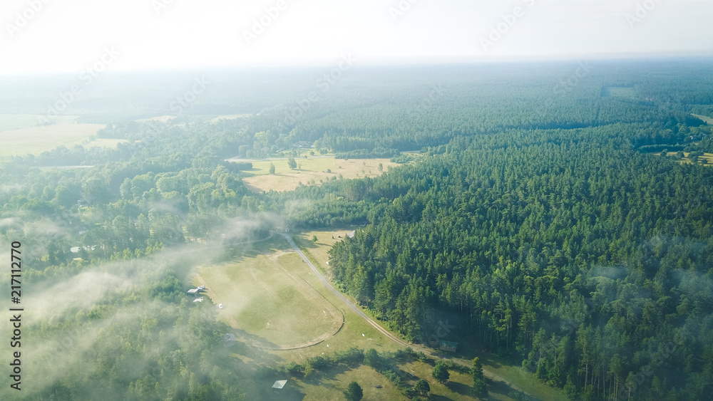 Misty sunrise over countryside path Aerial view Latvia