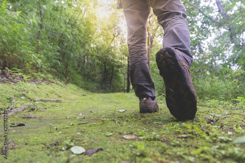 Feet in shoes on a forest path,Hikers boots on forest trail.