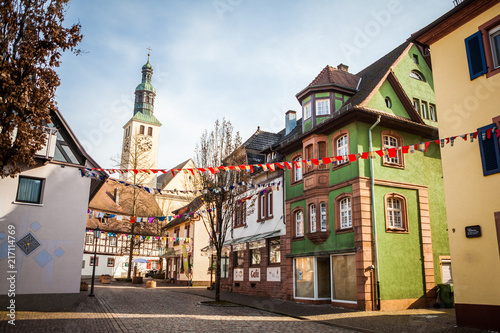 Perspective of a traditional alleyway in small town of Southern Germany with old architecture with decorations for national celebration