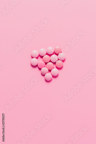 top view of heap of pink pills on pink surface