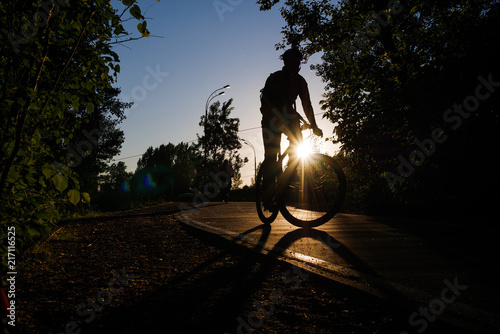 Image of bicyclist wearing helmet riding around city in evening