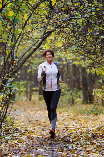 Photo of young girl running through autumn park © Sergey