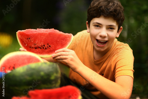 teenager boy with cut water melon close up photo photo