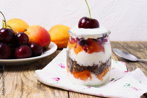 Glass dessert made of yogurt, granola, apricots and cherries