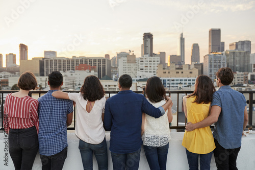 Rear View Of Friends Gathered On Rooftop Terrace Looking Out Over City Skyline © Monkey Business