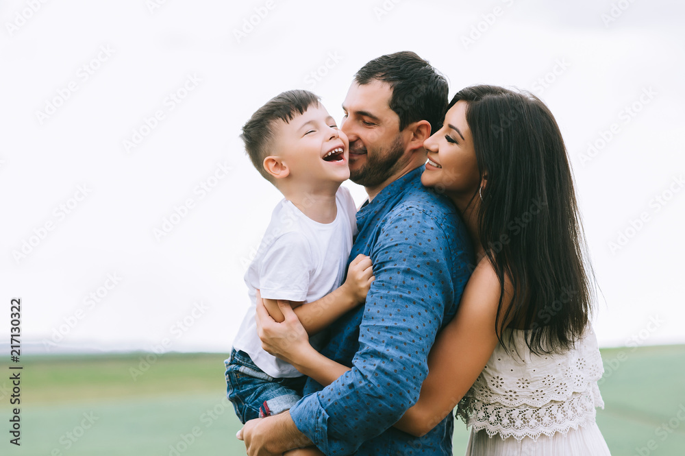 smiling parents and son having fun on field smiling parents and son having fun on field