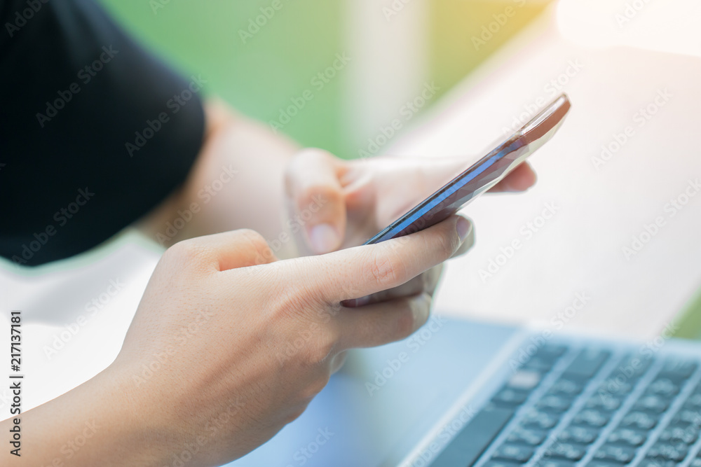 Fototapeta premium Online searching social networks by Smartphone Concept: Hand of Woman pointing finger on blank screen smart phone, using hand clean gadget or typing sms message to her friends in coffeeshop background