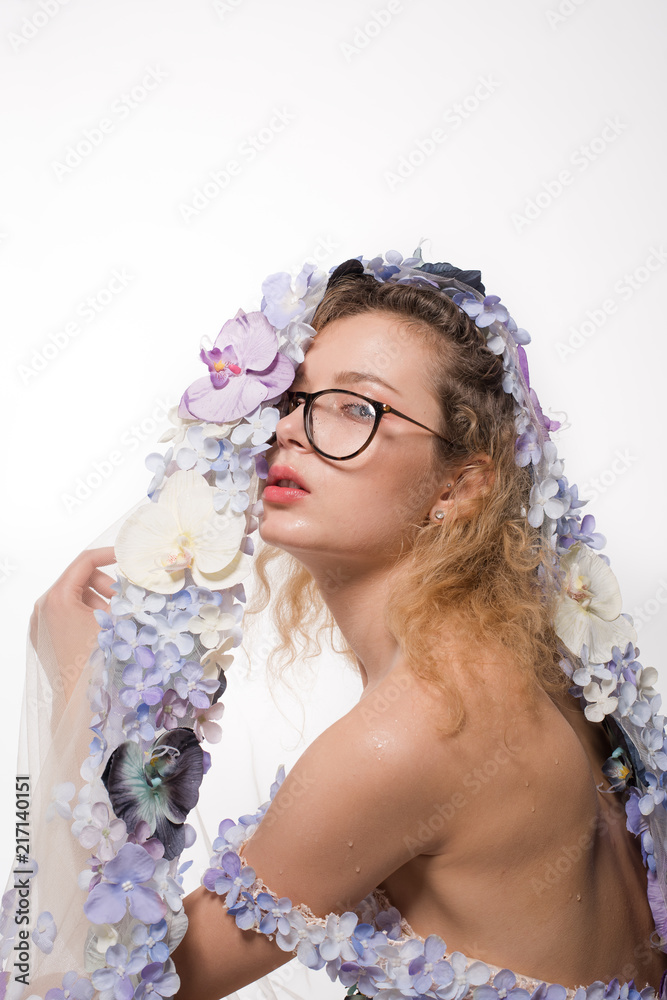 Pretty girl with glasses and with orchids on head on white background. Fashion Beauty Concept Pretty girl with glasses and with orchids on head on white background. Fashion Beauty Concept