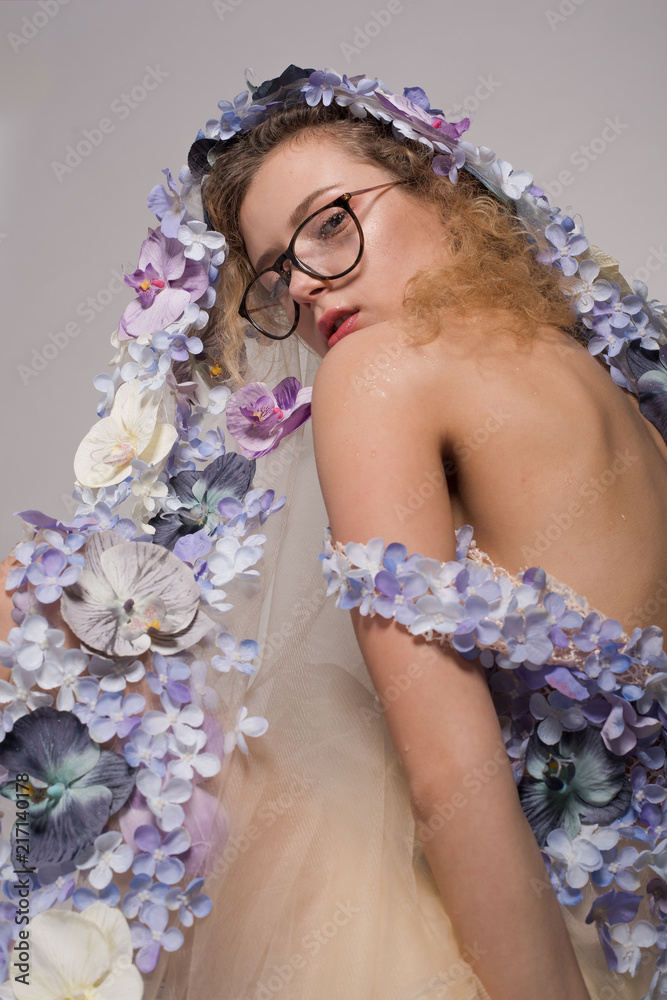 Pretty girl with glasses and with orchids on head on white background. Fashion Beauty Concept Pretty girl with glasses and with orchids on head on white background. Fashion Beauty Concept