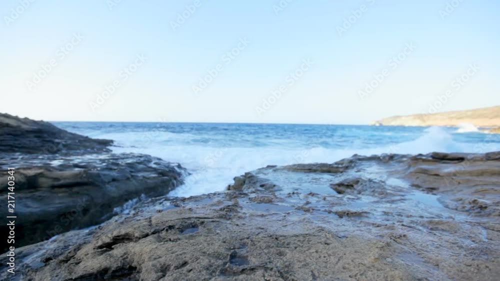 sea waves beat on the stone shore. Transparent sea blue water washes the stone shore on a sunny day. Greece sea waves beat on the stone shore. Transparent sea blue water washes the stone shore on a sunny day. Greece