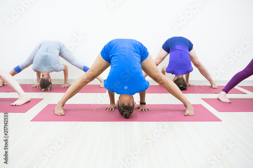 Group of positivel people practicing yoga in gym photo