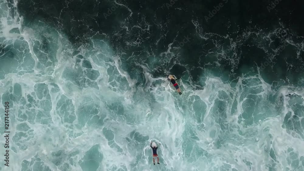 Two surfers paddling away from the shore break. Two surfers paddling away from the shore break.
