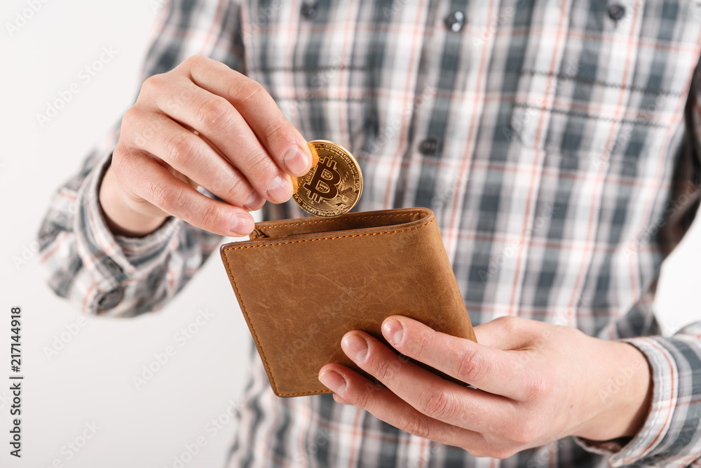 Obraz premium Businessman holding bitcoin. Golden bitcoin coin in men hands, pened wallet