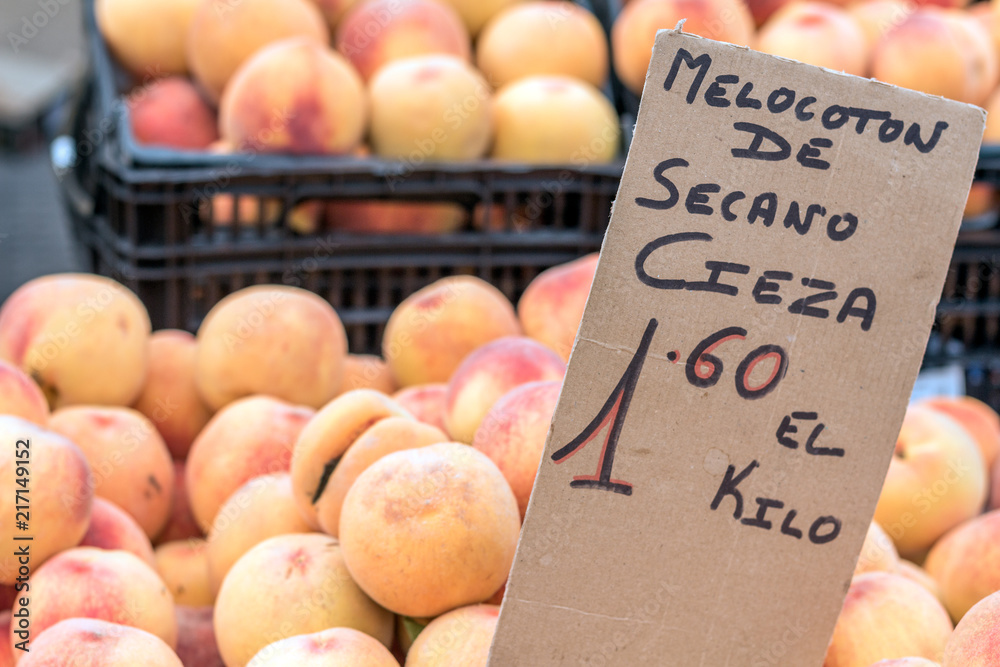 Peaches in street market (Torrevieja, Spain). Sign in spanish
