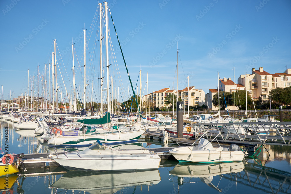 View of masts of yachts and sail boats with clear blue sky at the pier