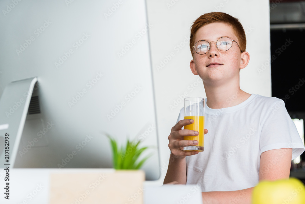 preteen ginger hair boy holding glass of juice at home preteen ginger hair boy holding glass of juice at home