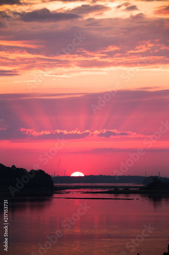 Bright  colorful evening landscape over the river Daugava of pink and purple tones. Dramatic sunset scenery in Latvia  Northern Europe.