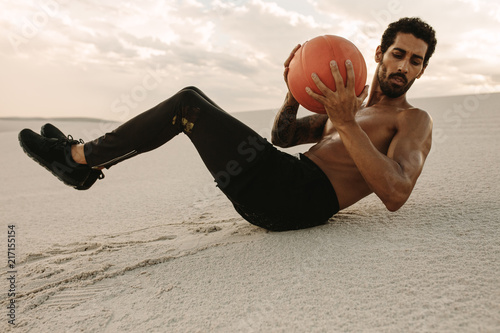 Athlete doing medicine ball workout in desert
