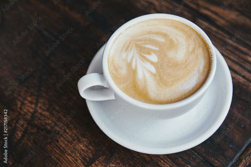 cup of fresh coffee with latte art on rustic wooden table cup of fresh coffee with latte art on rustic wooden table