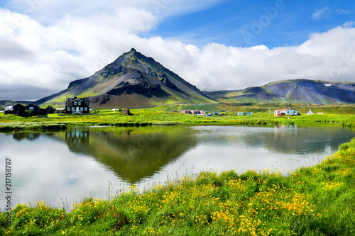 Beautiful fishing village view of Arnarstapi with water reflection of Mount Staoafell in the background at Snaefellsnes Peninsula, Iceland photo