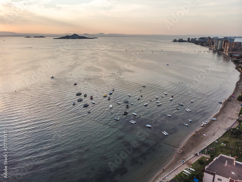 Sunset view on sandy arch of La Manga with its boat parking area, La Manga, Cartagena, Murcia, Spain, Summer 2018 from drone