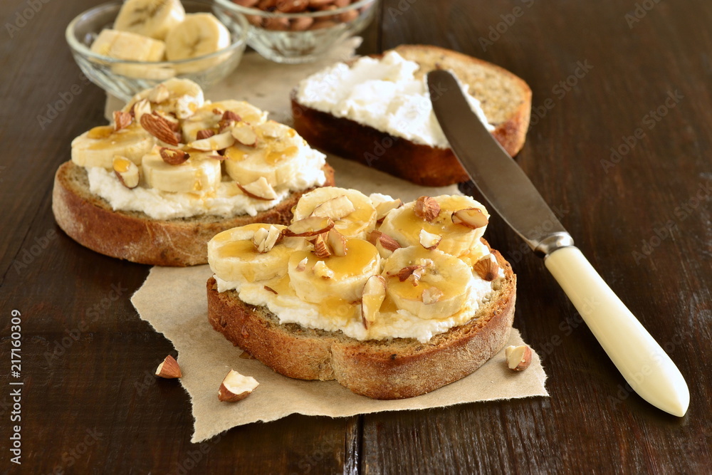 Toast with cream cheese, topped with banana, almonds and honey Toast with cream cheese, topped with banana, almonds and honey
