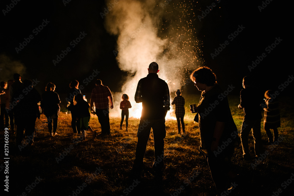 Group of people around a large bonfire Group of people around a large bonfire