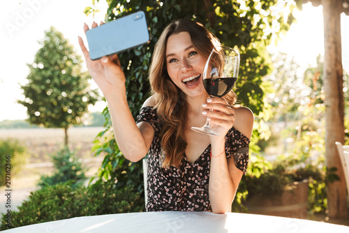 Woman sitting in cafe take a selfie by mobile phone.