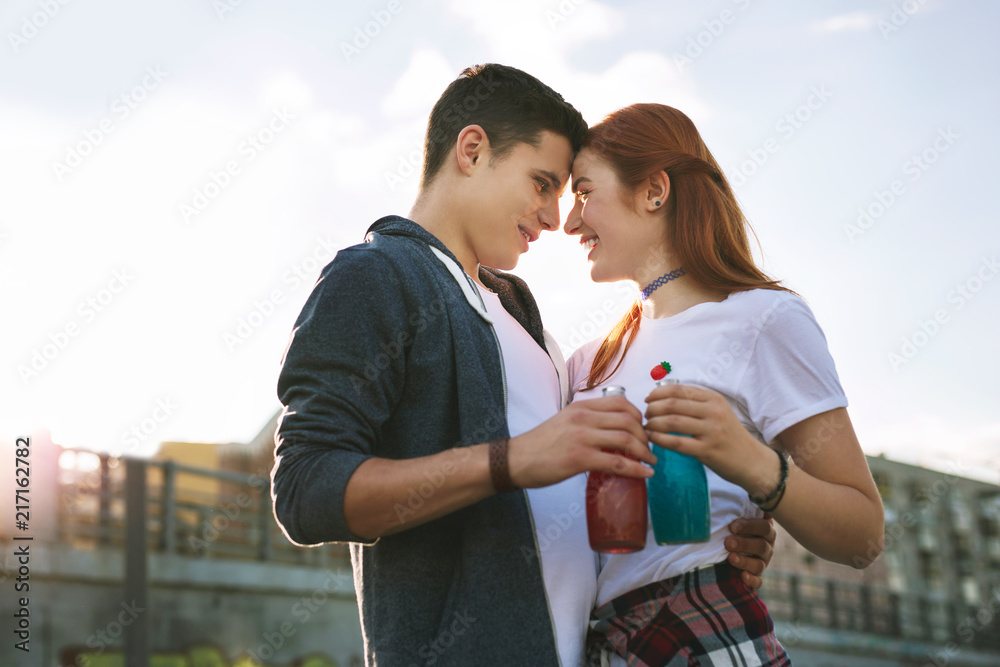 Romantic date. Positive young people holding their drinks while looking at each other Romantic date. Positive young people holding their drinks while looking at each other