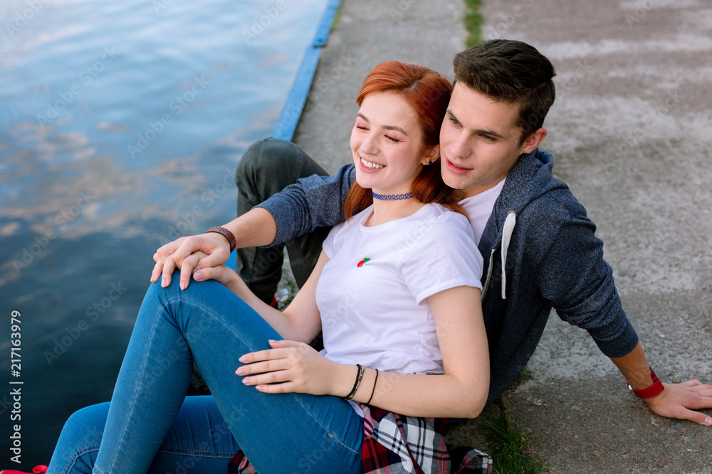 At the river. Happy nice couple being near the water while enjoying the river At the river. Happy nice couple being near the water while enjoying the river