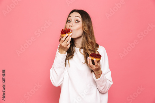 Canvas Print Portrait of a satisfied young woman eating pastry
